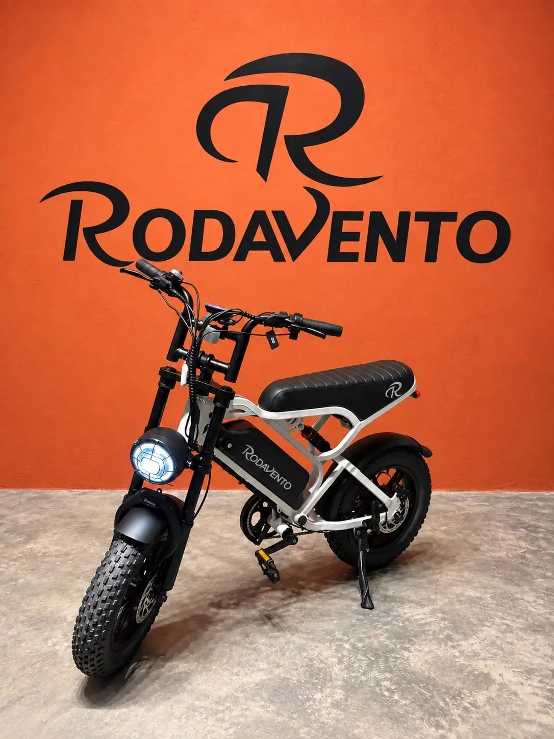 White RV Mini electric bike on the orange wall of the Rodavento store
